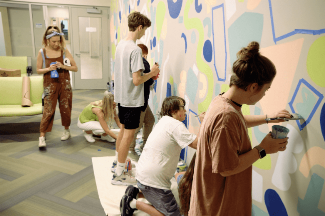 Volunteers painting mural at MUSC Summey Medical Pavilion