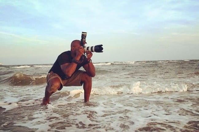 Photographer in the surf at the beach taking a photo