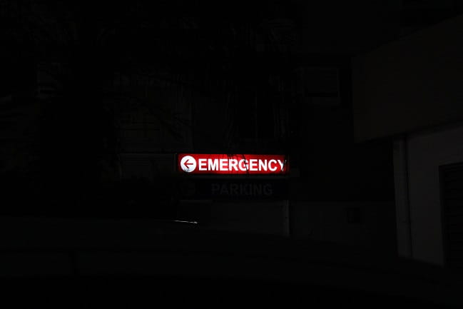 An emergency room sign lit up at night. 
