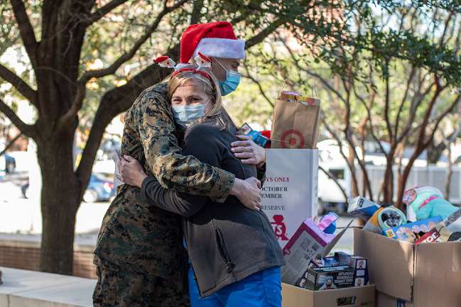 Lucas Perdue hugs registered nurse Starr Freedman after presenting, along with MUSC Health, mountains of collected toys to the Marines for Toys for Tots.