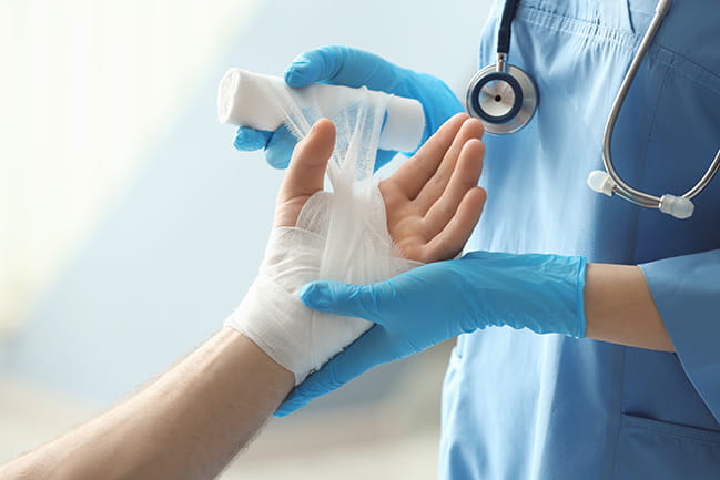 Health care provider treating a hand injury.