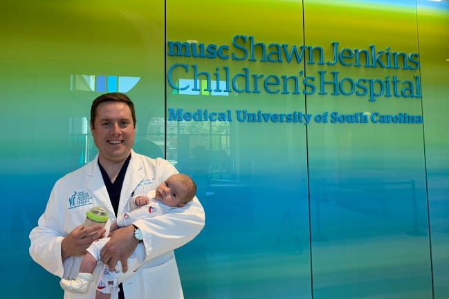 Dr. Lucas McDuffie with healthy baby Banks following the successful surgery.