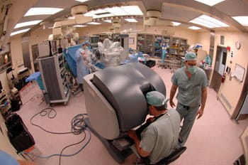 Surgeon performs robotic laproscopic surgery.