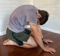 MUSC Physical Therapist Aaron Brown demonstrates a thoracic extension stretch called the short kneeling cat-cow.