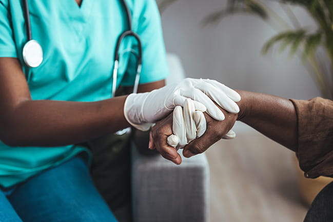 Care team member holding hand of patient