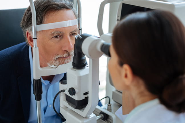 A patient's eye is examined by a clinician.