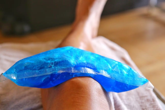 Hand holding an icepack on a knee