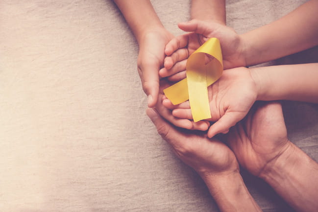Hands holding a yellow ribbon