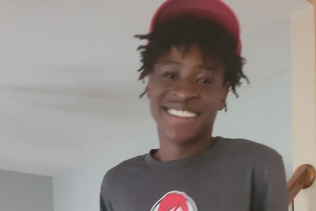 Smiling teen (Anthony) wearing baseball cap.