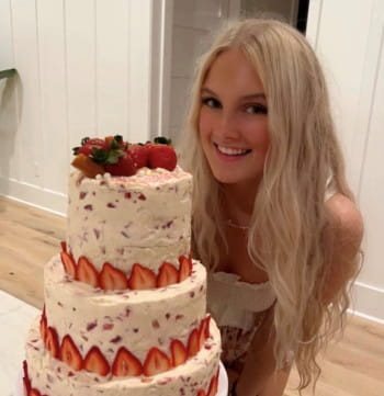 Smiling teen with a multi-layered strawberry cake