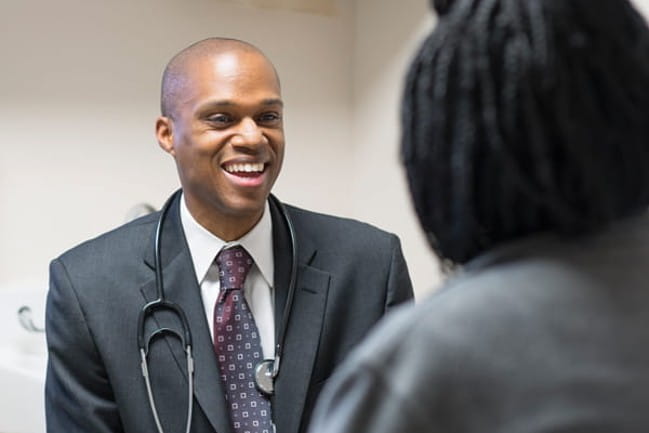 A smiling Dr. Nathan Rowland with a patient.