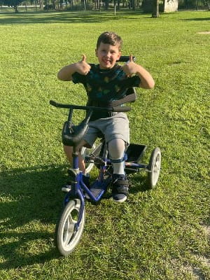 Jude giving a smiley thumbs-up while seated on his bike.