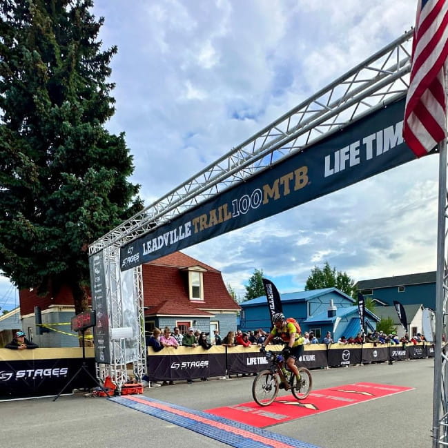 Zachary Sutton crossing finish line on a bicycle