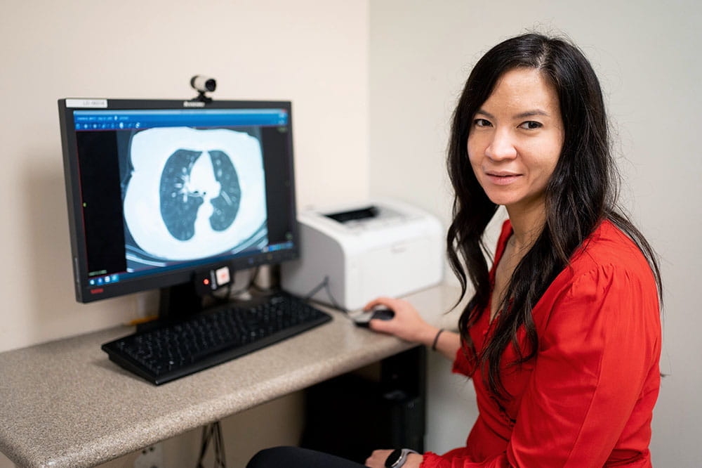 Dr. Nichole Tanner, lung cancer pulmonologist, in front of a computer