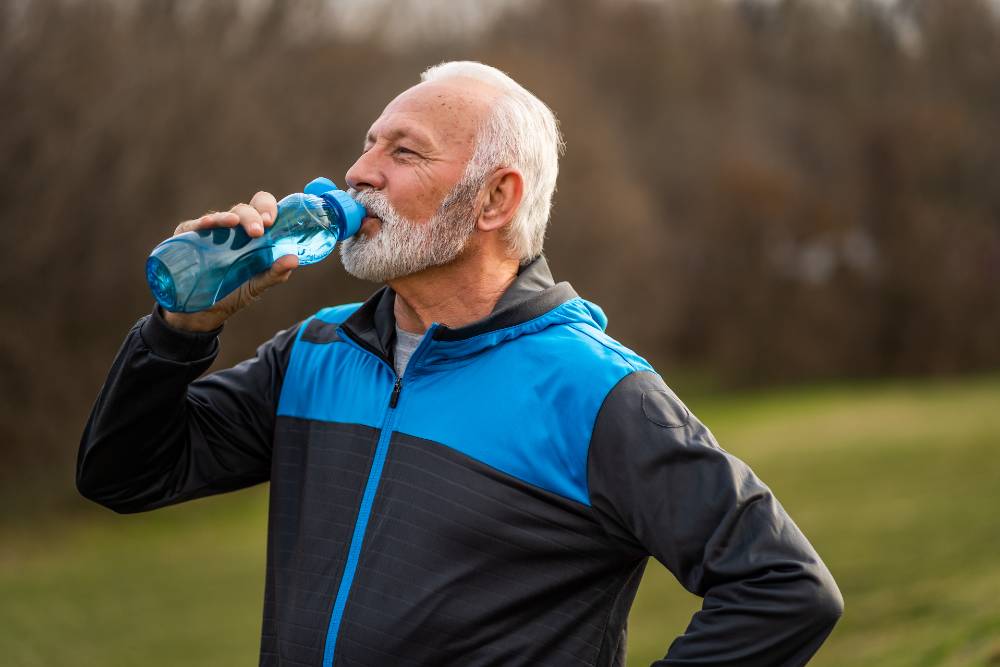 Senior man is drinking water after exercising.