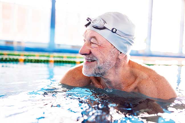 An elderly man swimming.