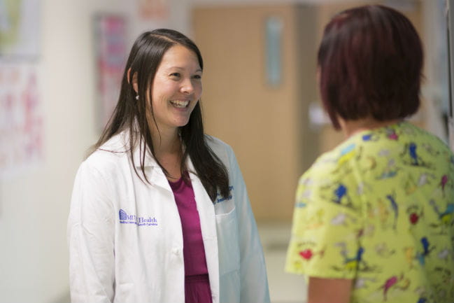 Dr. Kelli Williams speaking with another care team member.